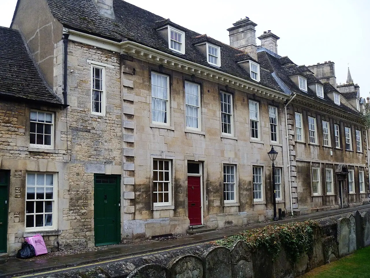 A row of stone townhouses with coloured doors beside St George’s Square in Stamford