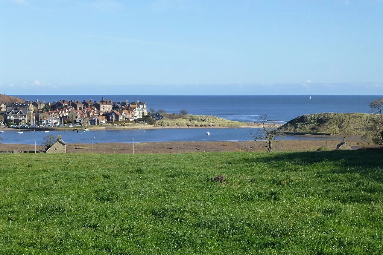 Alnmouth village beyond coastal grassland and the river mouth
