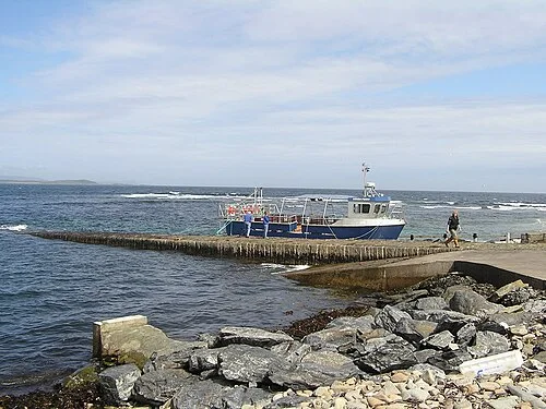 A boat moored alongside the stone pier at Sandsayre