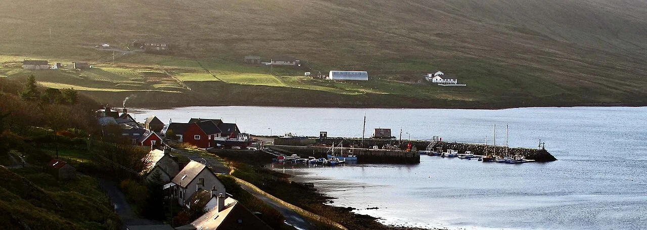 Lower Voe harbour and waterfront buildings beneath the hills